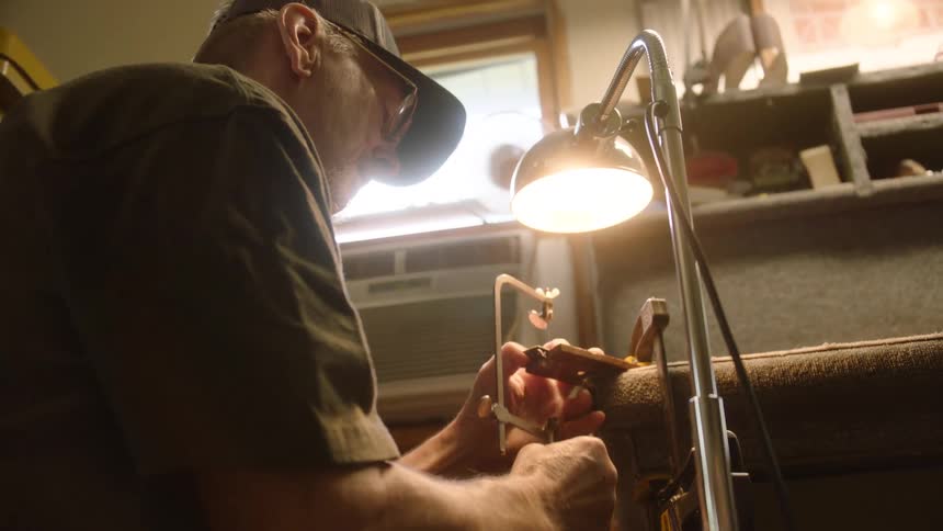 A skilled artisan meticulously cuts a piece of wood with a hand saw in his workshop
