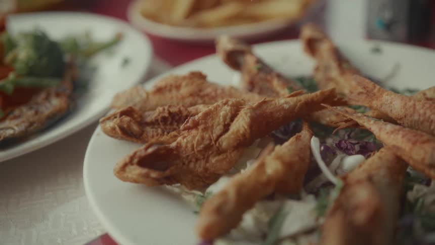 A shallow depth of field close up of a plate of fried fish at a restaurant