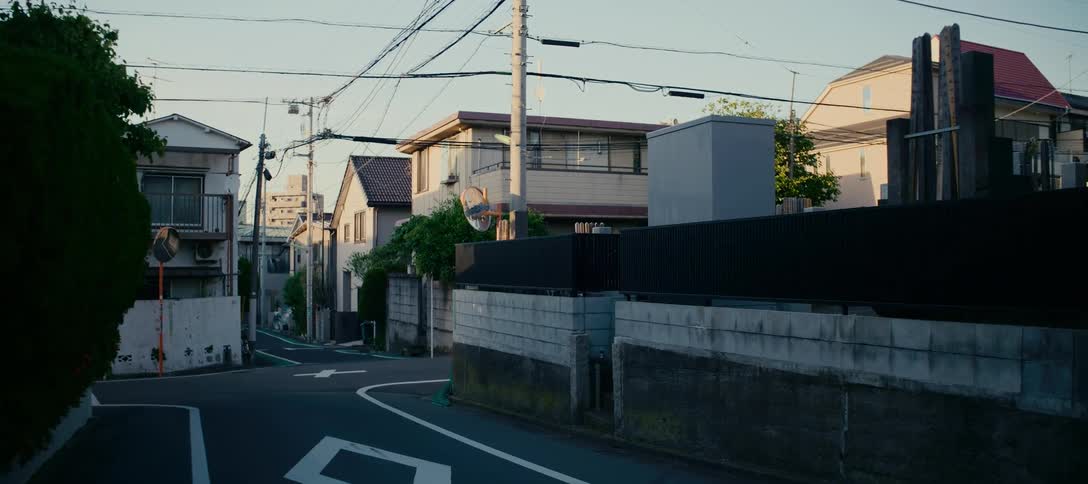 A quiet, empty street corner in a residential neighborhood in Japan at dusk