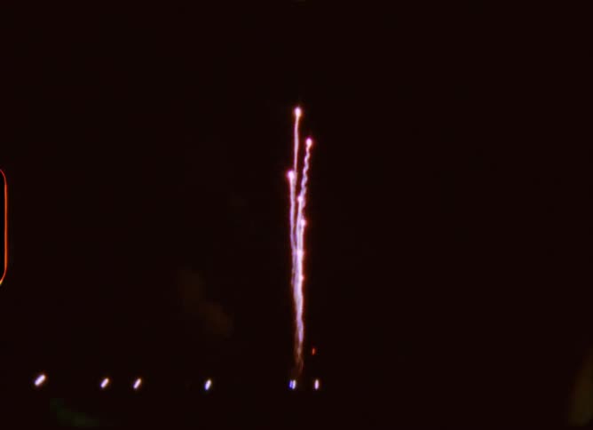 Authentic 8mm film captures a colorful fireworks display exploding in the night sky