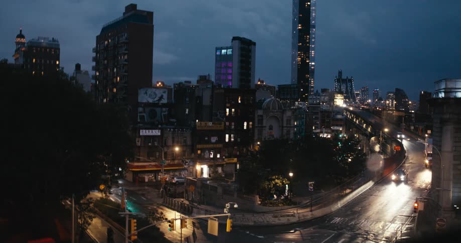 Long exposure captures the light trails of traffic moving through a moody New York City streetscape at twilight
