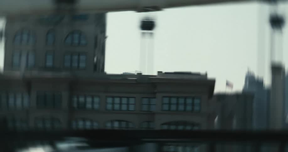 A fast-paced, cinematic tracking shot from a moving vehicle reveals the iconic Brooklyn Bridge and the Lower Manhattan skyline