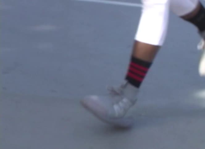 A low-angle shot follows the swift movements of a basketball player's sneakers on the court