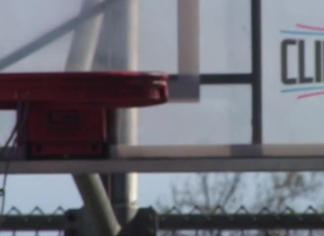 A basketball player makes a perfect shot into the hoop on an outdoor basketball court
