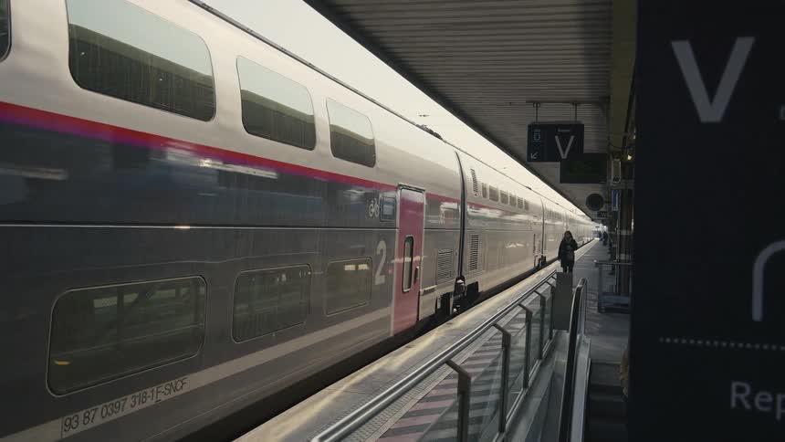 A sleek high-speed train gracefully departs from a sunlit station platform