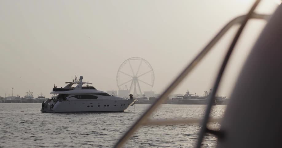 A boat anchored in the water near a pier at sunset