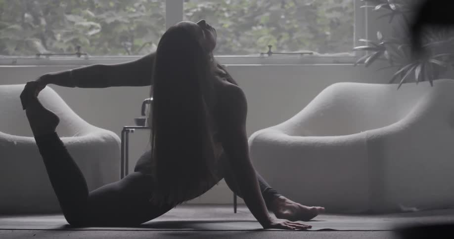 A woman is stretching in a living room