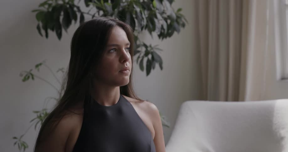 A woman is meditating in her living room