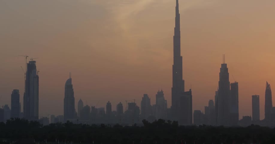 A tall tower sits in the middle of a city at dawn