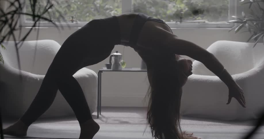A woman is doing yoga in the living room