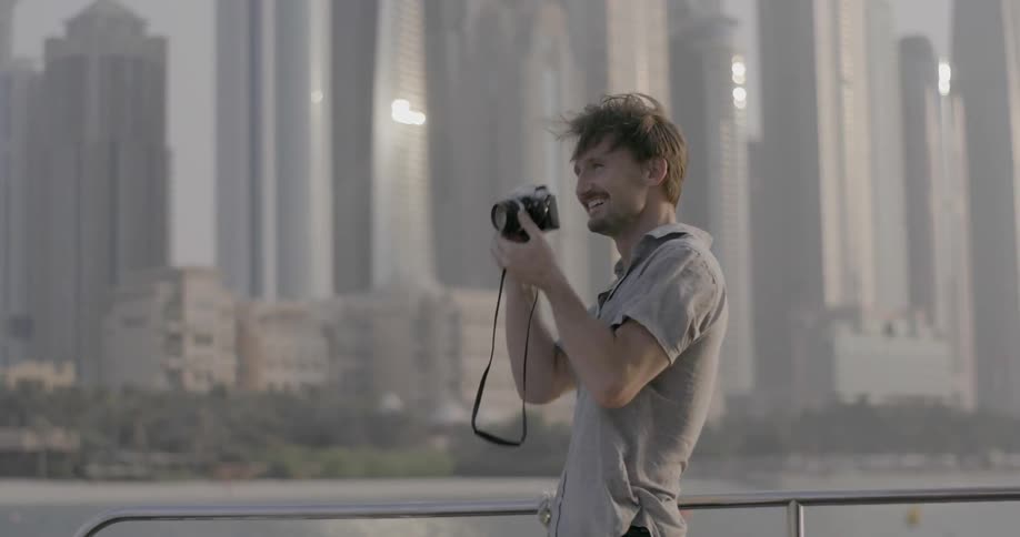 A man holds a camera on a boat
