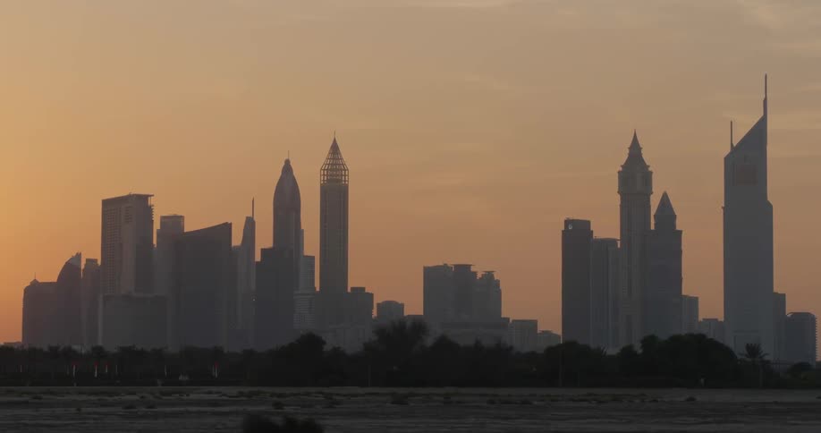 The sun is setting behind the city ahead