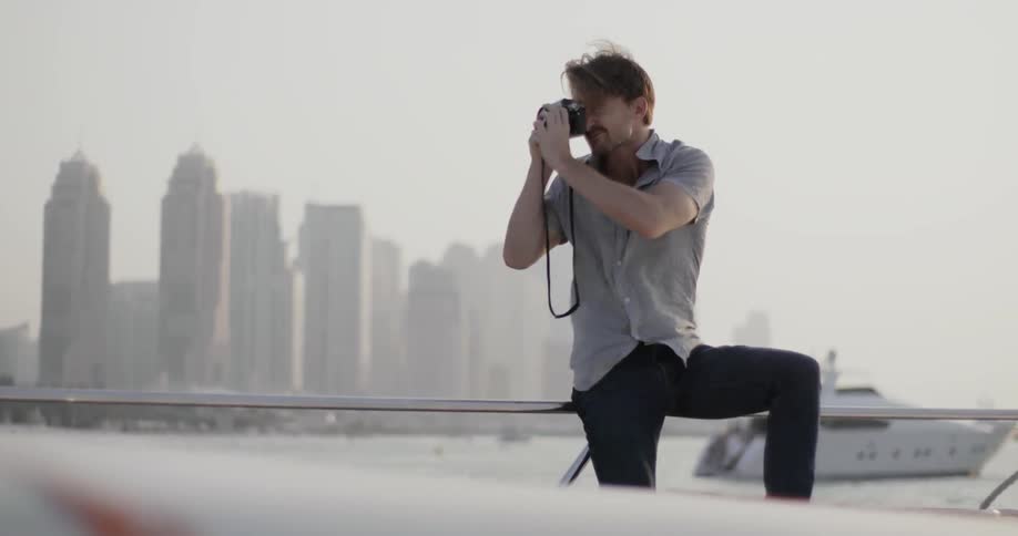 A man lifts up his camera and takes a photograph