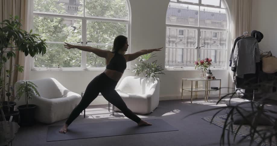 A woman stretches doing yoga at home