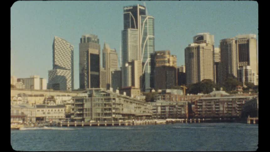 Super 8 film captures a view of the Sydney city skyline and harbor front buildings on a clear day