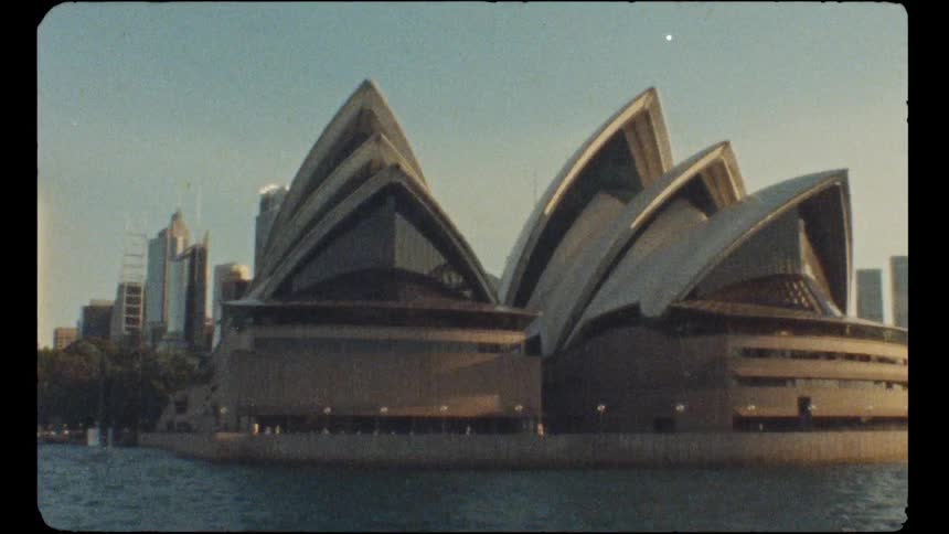 A vintage film captures a moving view of the iconic Sydney Opera House and the city skyline from the water