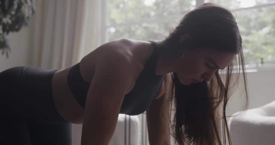 A woman does yoga in a living room