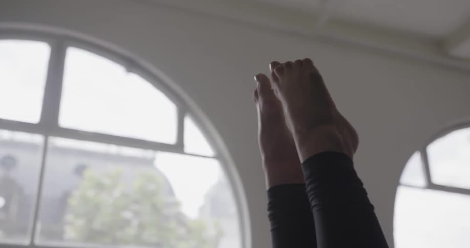 A person's feet in the air inside a home