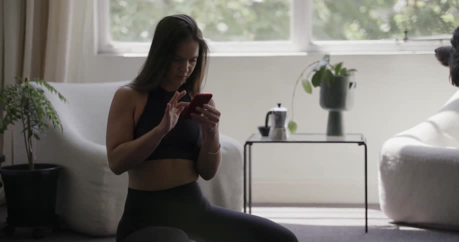 A woman is using her phone in the living room
