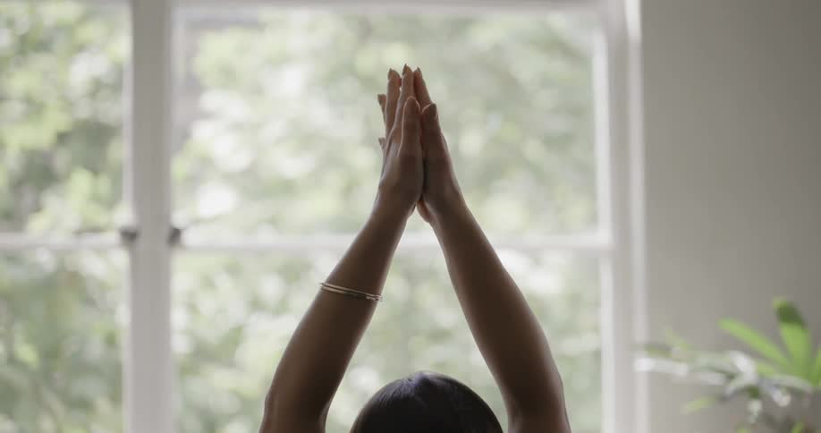A young woman is doing yoga in a living room
