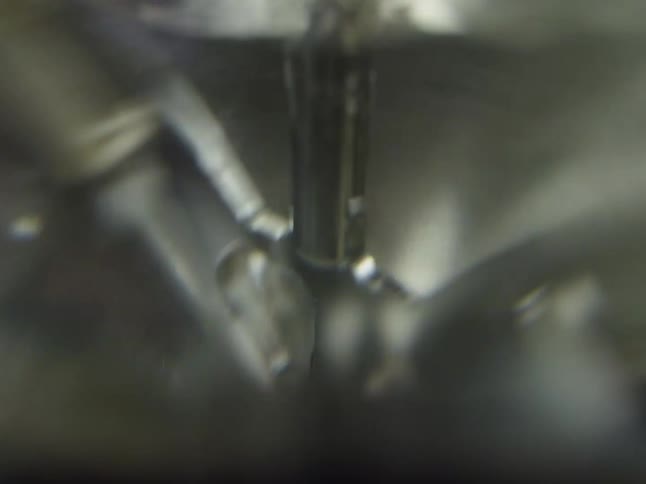 Abstract macro shot of a shiny, metallic industrial machine operating at high speed
