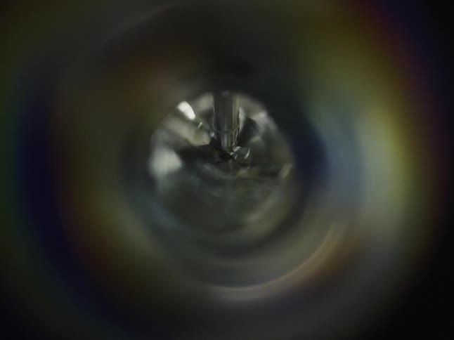Hypnotic abstract macro shot of an industrial mixer spinning in a liquid, creating a whirlpool effect
