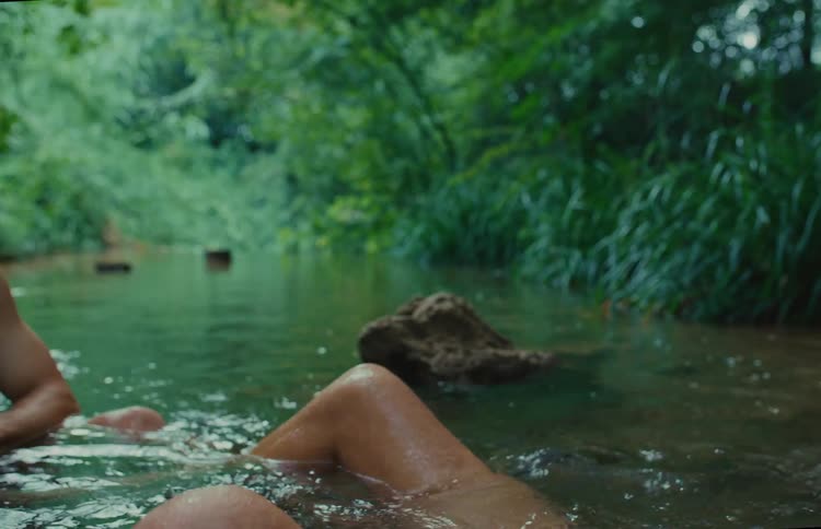 A man cools off and washes his hair while enjoying a relaxing swim in a tranquil jungle river