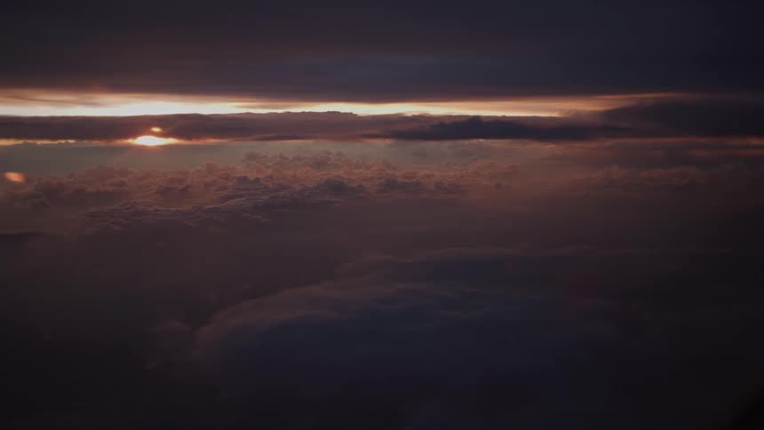 A stunning aerial view of a dramatic sunset over a vast sea of clouds