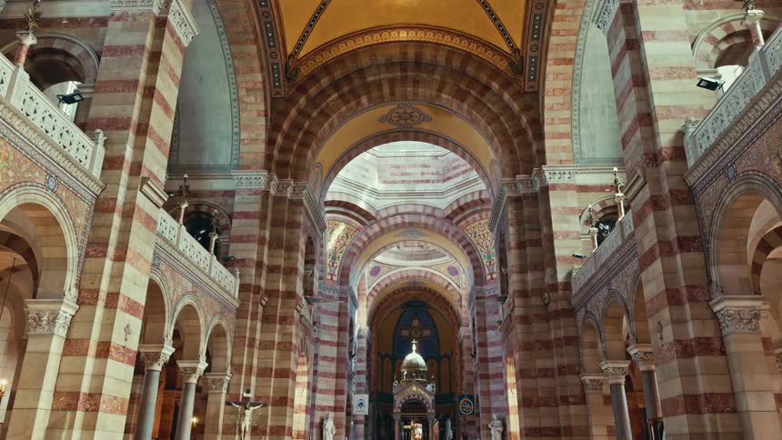 The grand and serene interior of a historic cathedral with towering striped columns and ornate arches leading to the altar