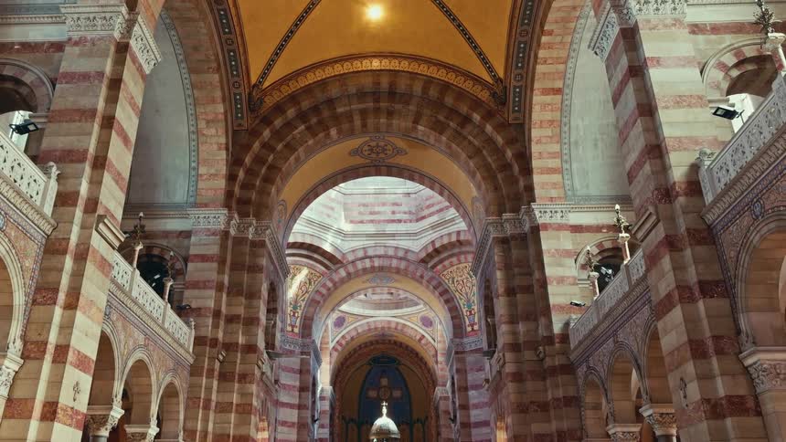 A slow tilt down reveals the magnificent, sunlit interior of a grand cathedral with ornate arches and vaulted ceilings