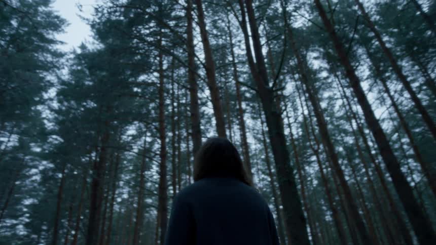 A woman is walking in the woods