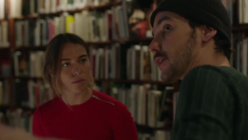 Man and woman talking animatedly in a library