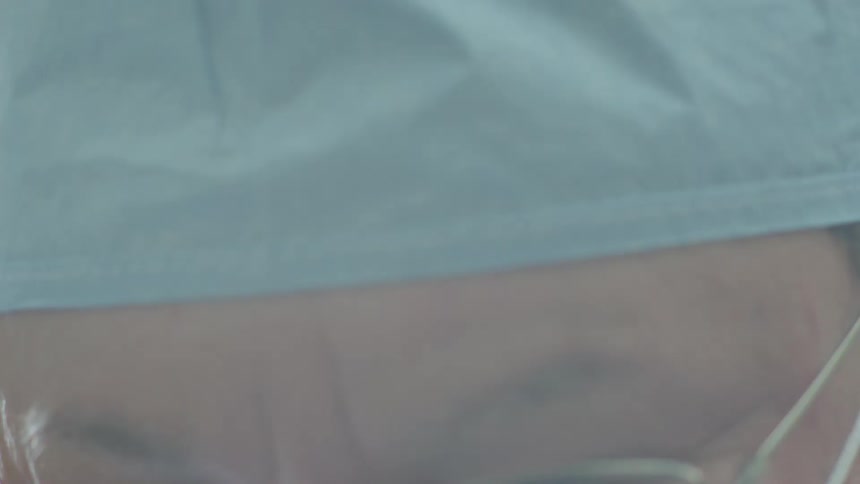 A slow-motion extreme close-up of a surgeon's face, revealing intense concentration through their glasses and mask