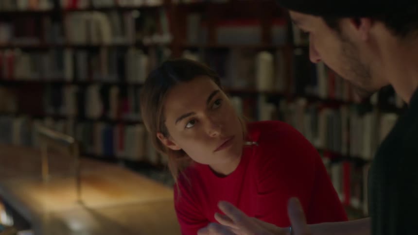 A man and women talk in a library