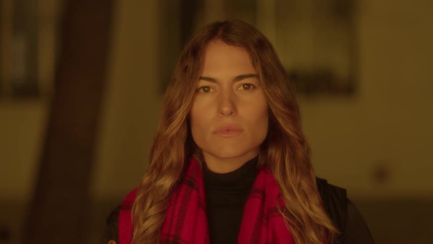 A woman in a plaid scarf looks forward
