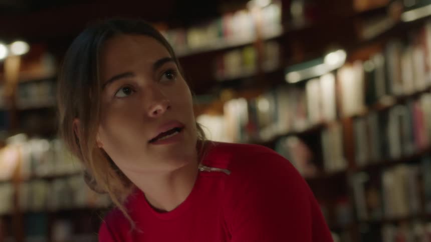 A woman talks with a man in a library