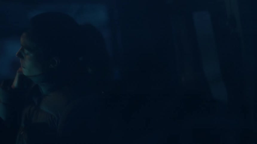 A woman is standing outside in the dark
