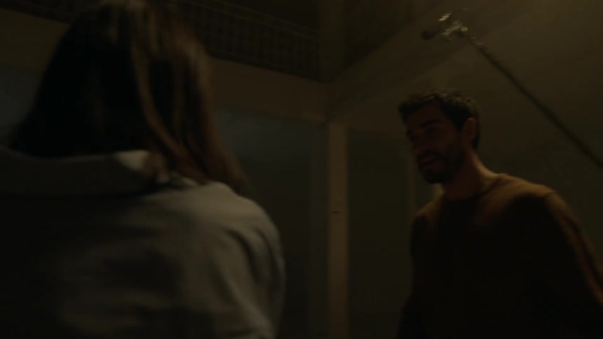People walk down a dark hall