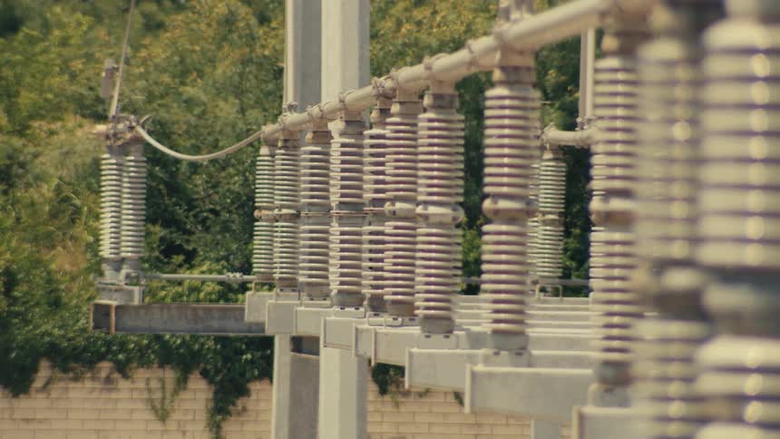 Cinematic pan reveals the details of high-voltage ceramic insulators at a power substation