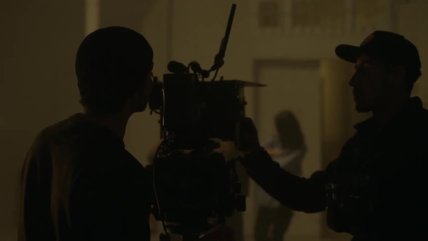A film crew shoot a scene between a man and a woman
