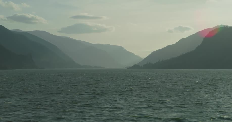 A serene view of the vast Columbia River Gorge with layers of hazy mountains stretching into the distance