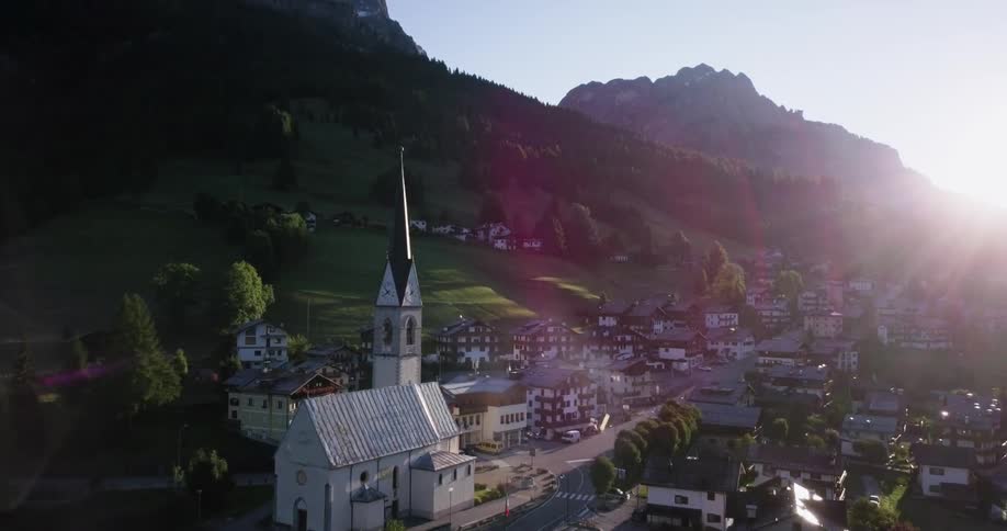An overhead and side view of a church and some buildings in a town