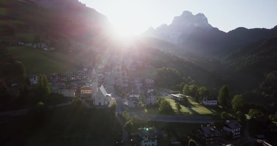Sun shining on a town nestled in the mountains