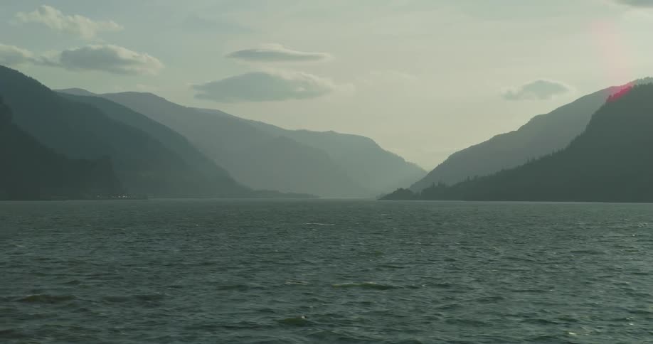 A tranquil and hazy wide shot of the majestic Columbia River Gorge with layered mountains fading into the distance