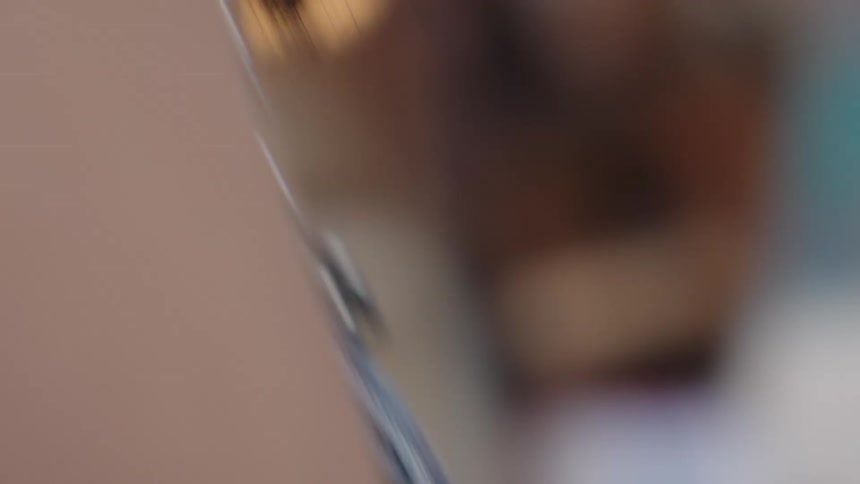 An artist with paint on her hands works intently on her laptop in a close-up, intimate shot