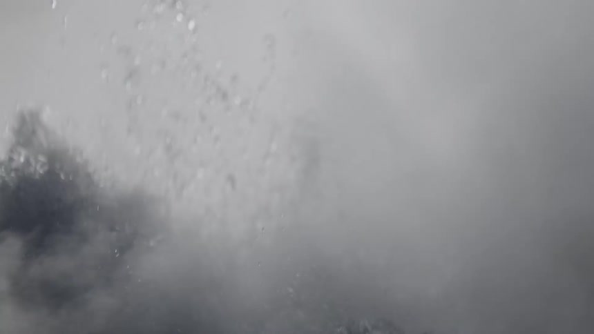 A mesmerizing black and white slow-motion close-up of turbulent water bubbling and splashing