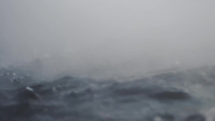 An abstract, slow-motion, and close-up view shows steaming hot water as it churns and splashes