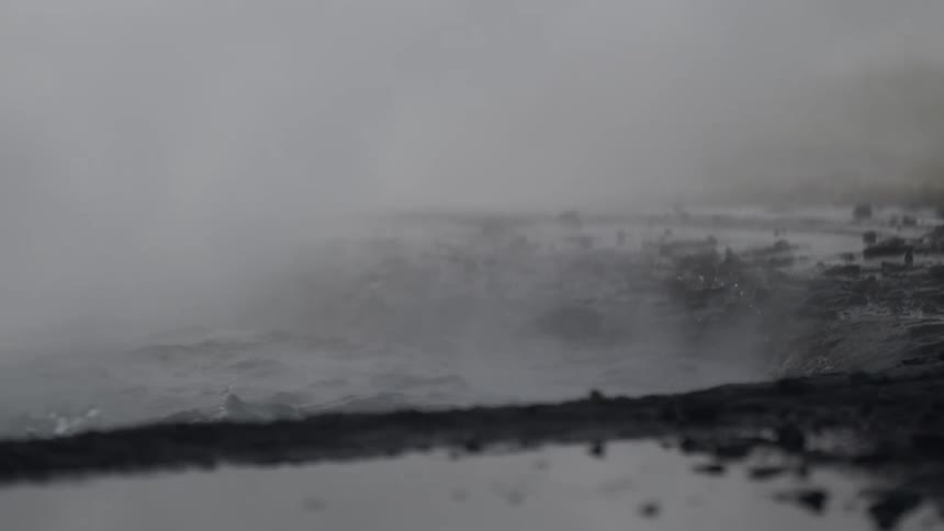Close up slow motion of a steaming volcanic mud pot bubbling