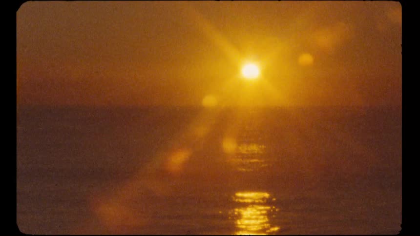 A dreamy, vintage-style shot captures the golden sun setting over the calm ocean, creating a shimmering reflection and a warm lens flare
