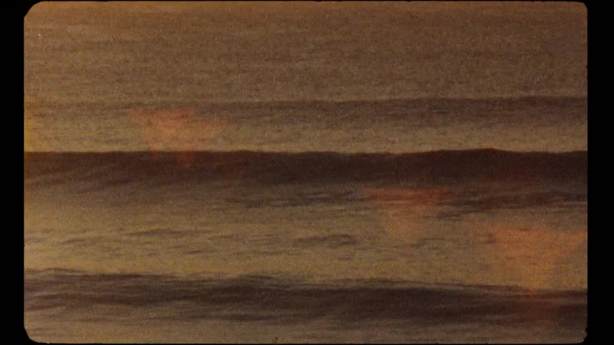 Nostalgic Super 8mm film captures the tranquil ocean waves with a warm, grainy texture